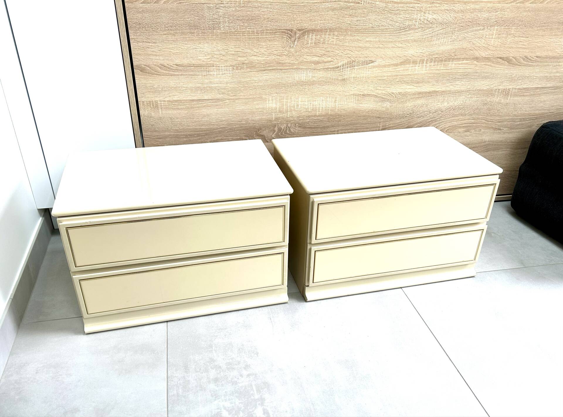 Pair of bedside tables with 2 drawers, glossy cream and gold, 1980.