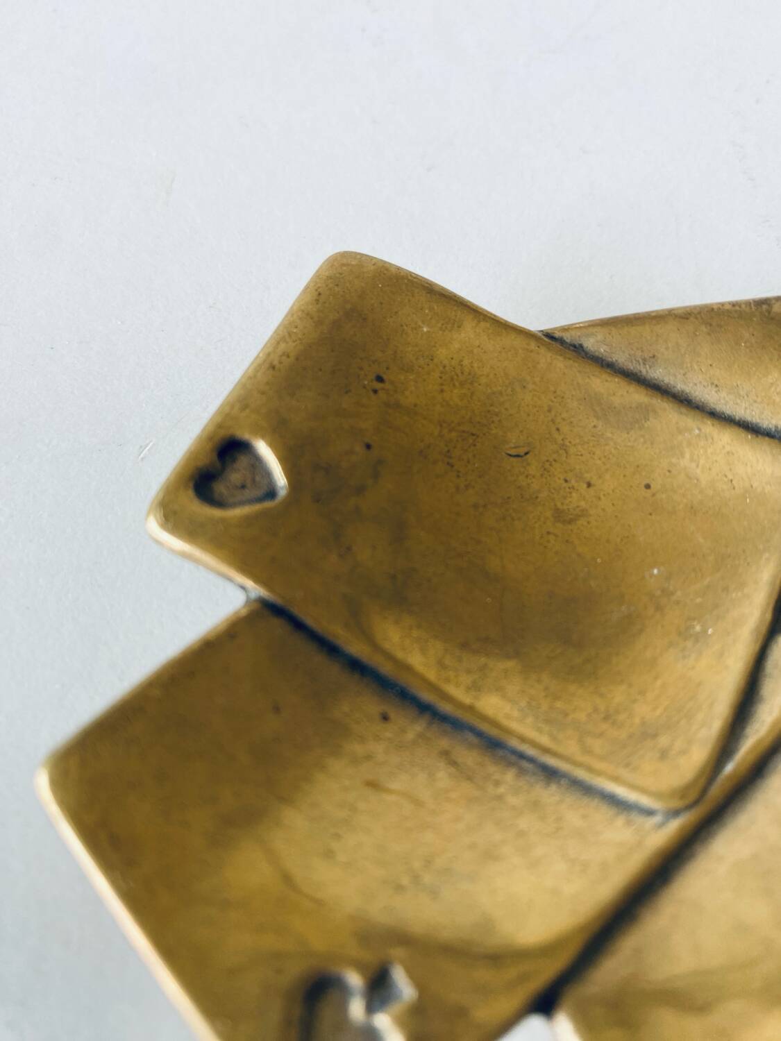 Empty pocket square of aces in brass