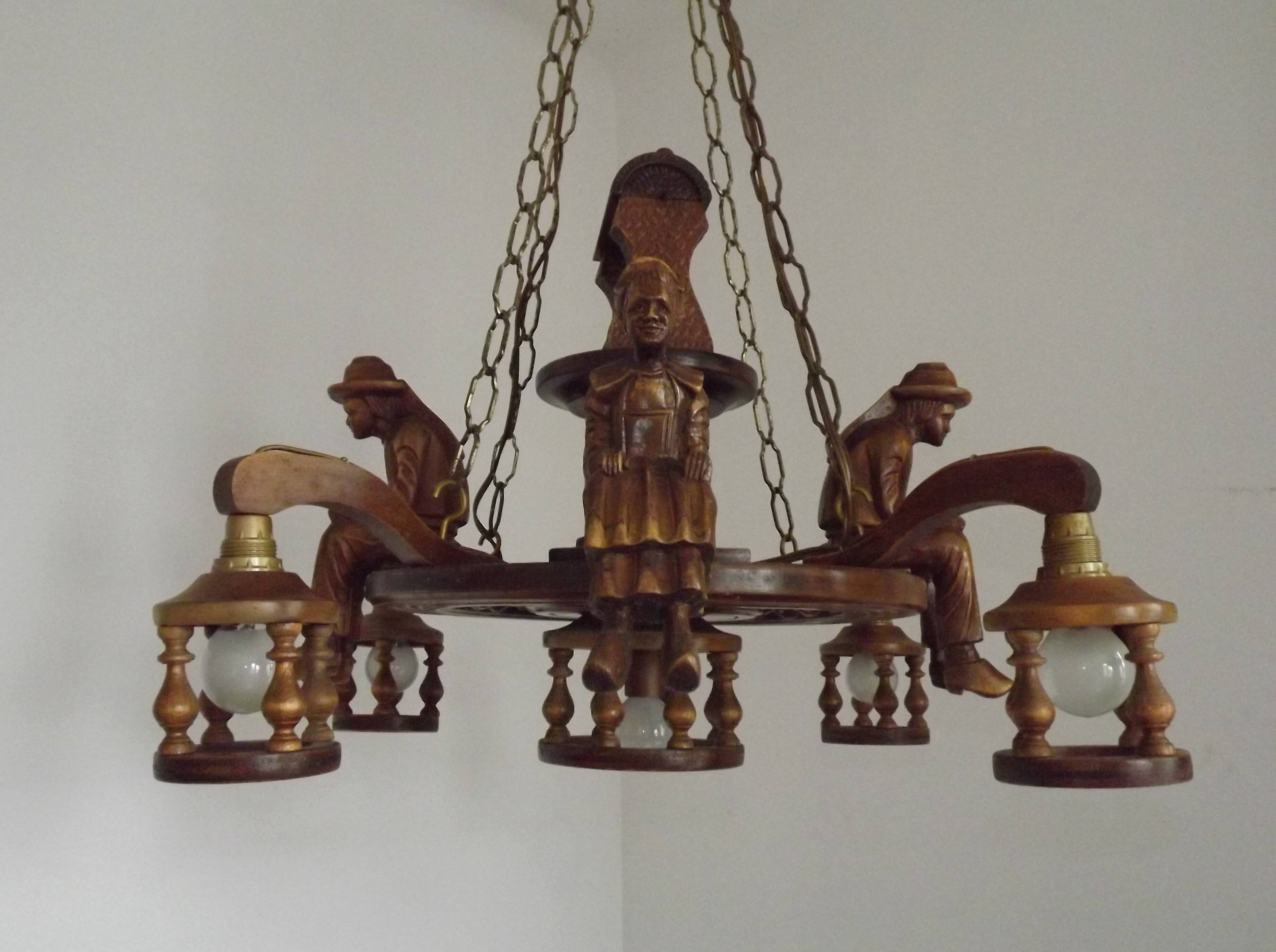 French vintage Breton chandelier with hand-carved figures, well, and lantern lights.
