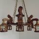 French vintage Breton chandelier with hand-carved figures, well, and lantern lights.