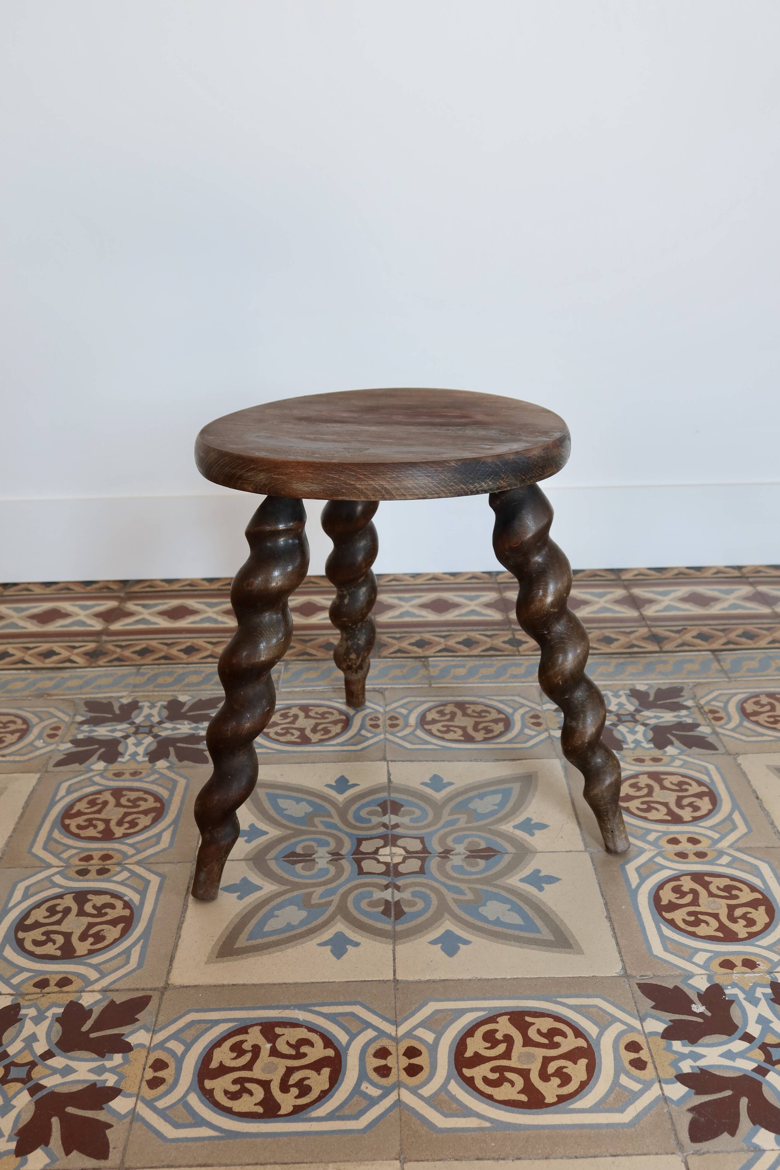 Antique tripod stool made of turned wood.