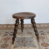 Antique tripod stool made of turned wood.
