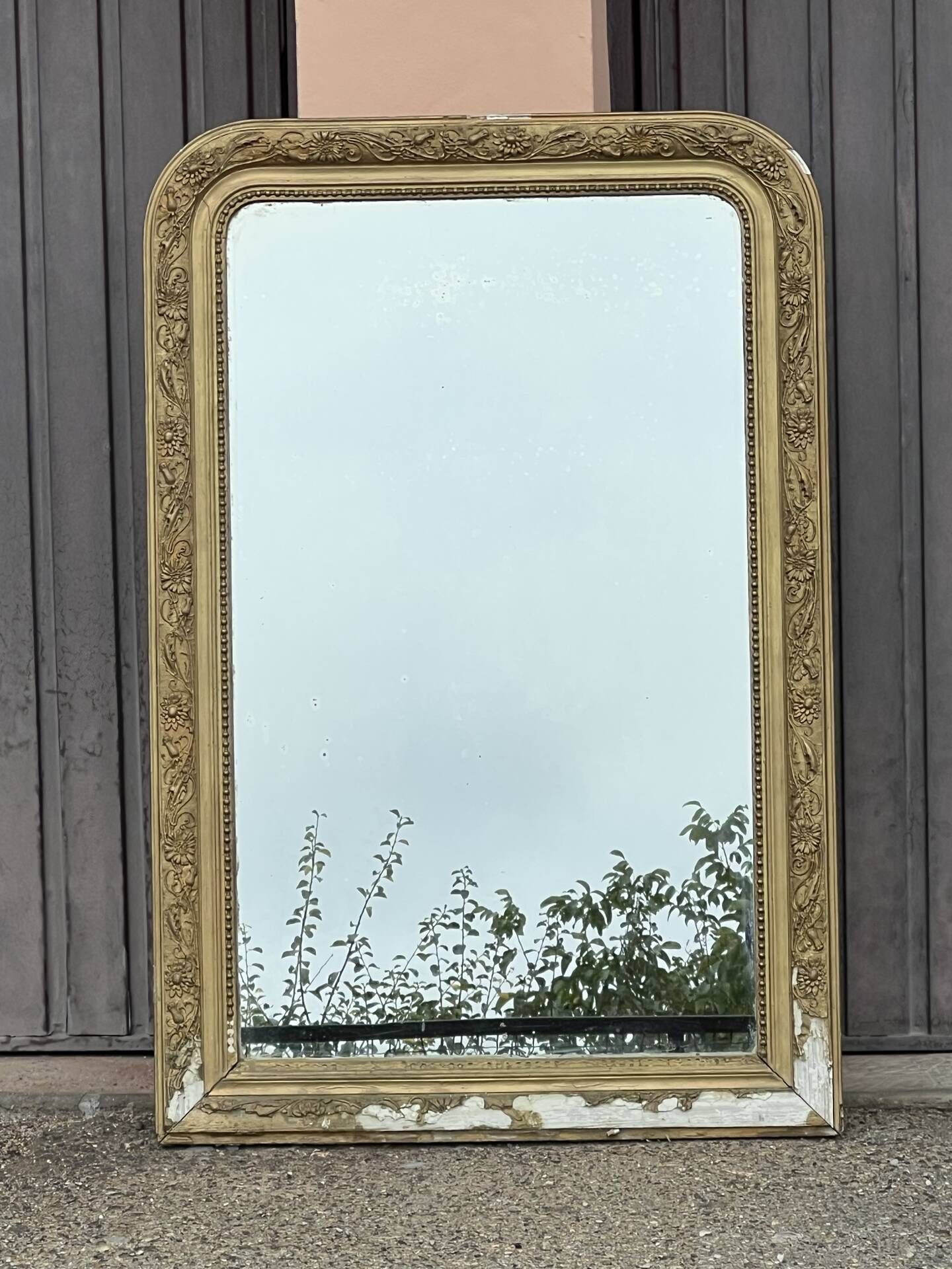 Large Louis Philippe mirror in carved gilded wood with mercury glass.