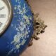 Wall clock in glazed earthenware decoration and brass chain empire style