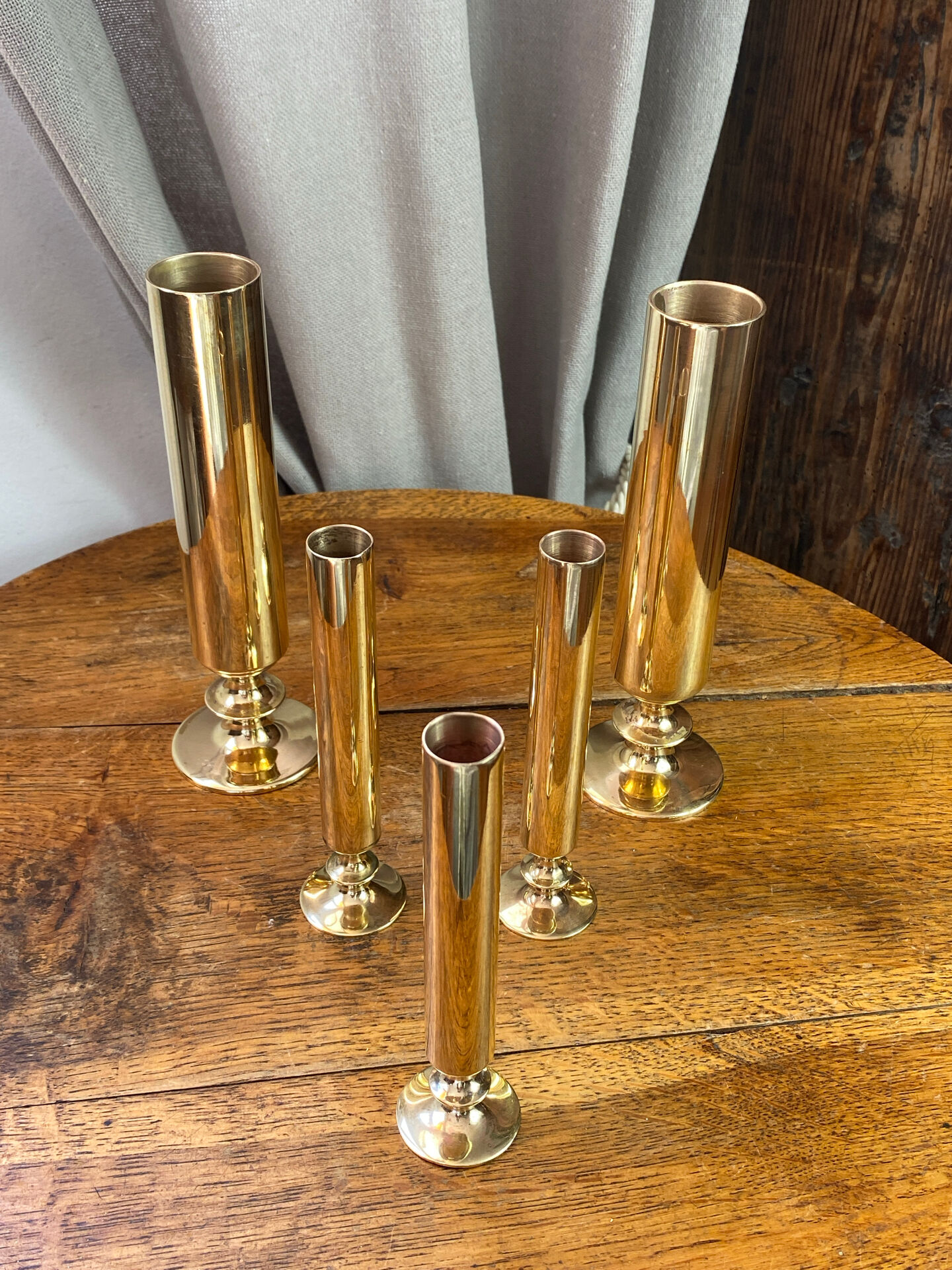 Set of candlesticks and tubular vases in solid brass.