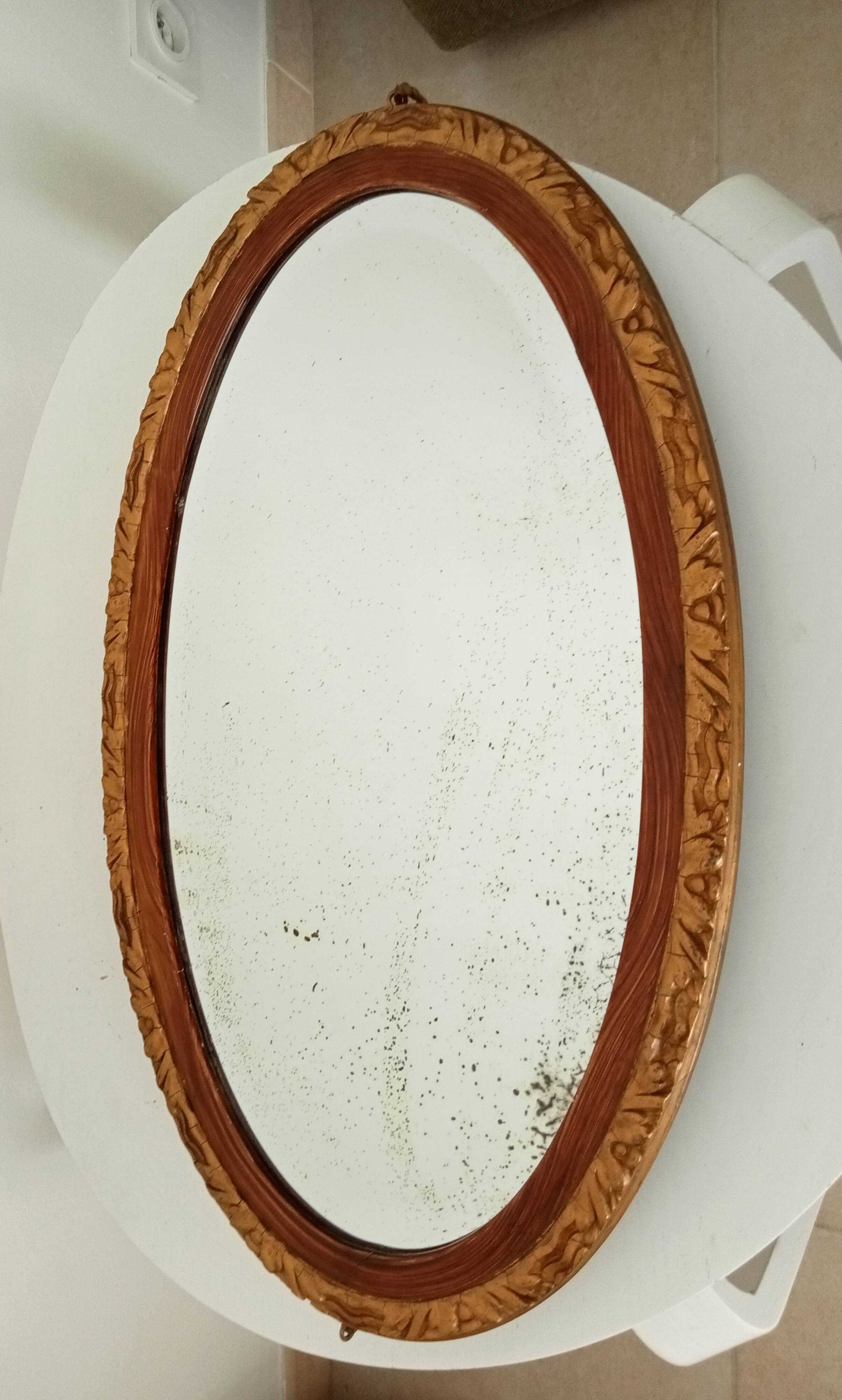 Antique oval mirror with beveled glass in wood and stucco, 19th century