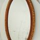 Antique oval mirror with beveled glass in wood and stucco, 19th century