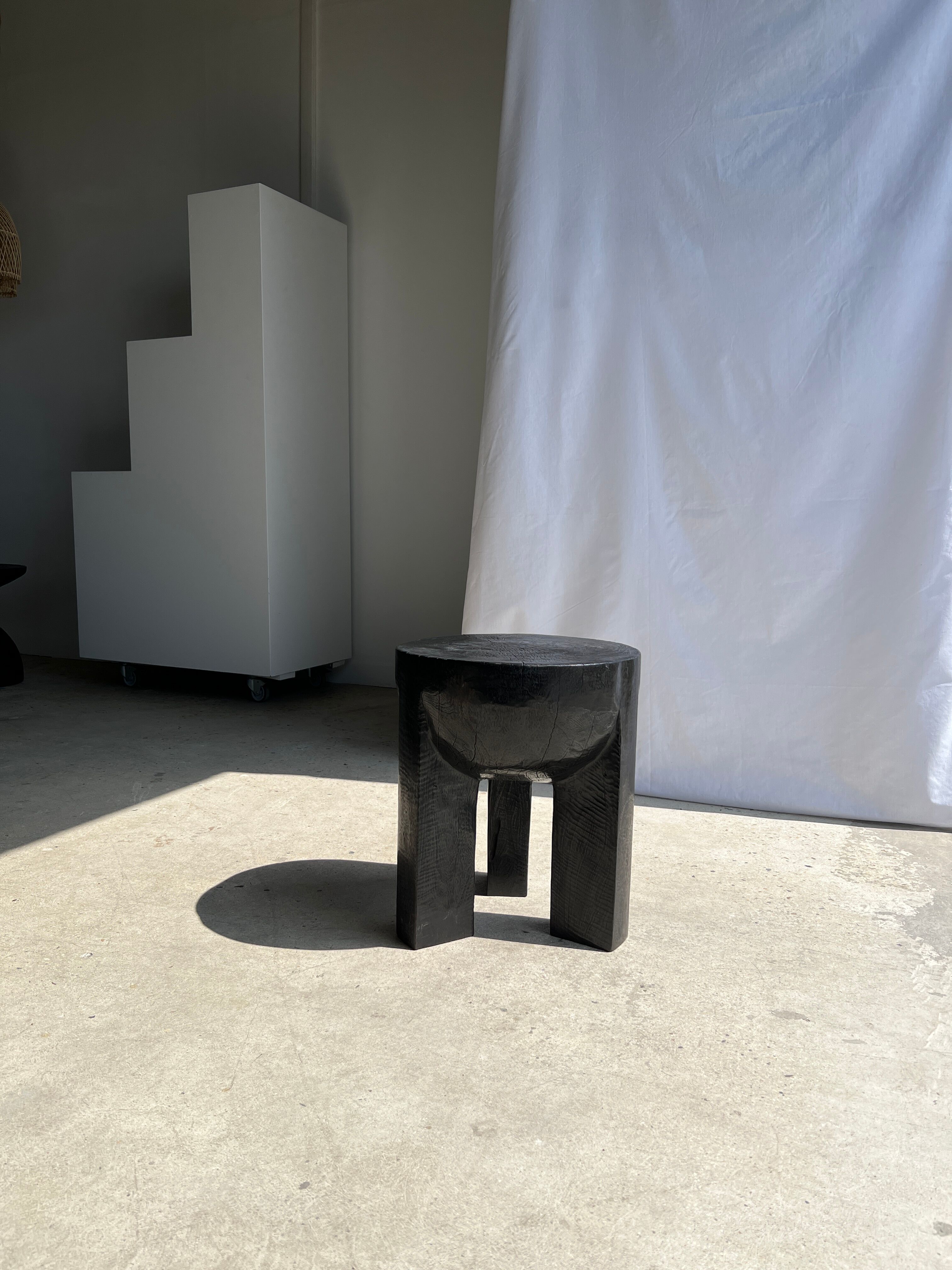 Black mango wood tripod side table with a semi-spherical top, height: 45 cm, diameter: 44 cm.