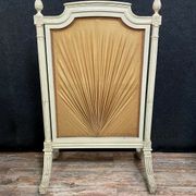 Front of Louis XVI fireplace in laqué wood and fabric has floral decorations