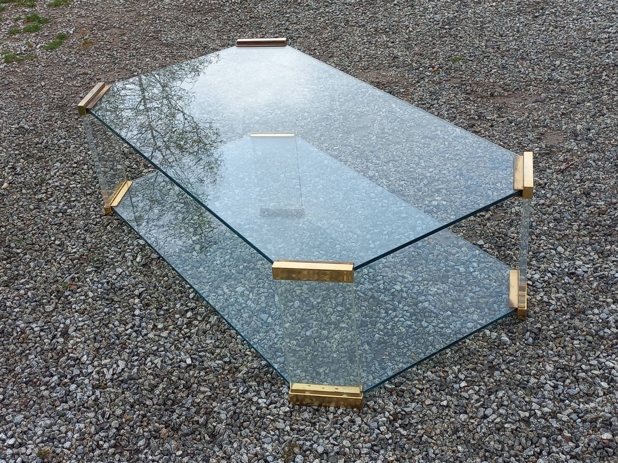 1970s designer coffee table in glass, plexiglass, and gold metal.