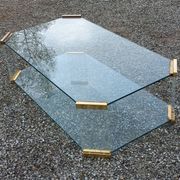 1970s designer coffee table in glass, plexiglass, and gold metal.