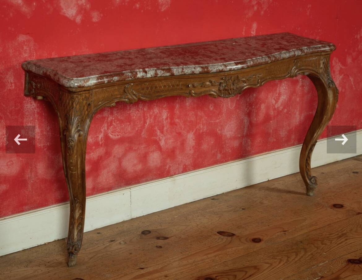 Important console in natural wood, moulded and carved with a red marble top.