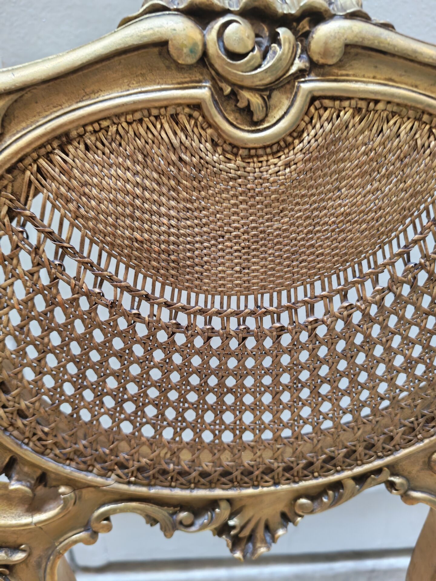 Antique rococo chair in gilded wood and caning