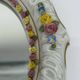 Antique porcelain mirror from Dresden with relief flowers and rococo decoration.