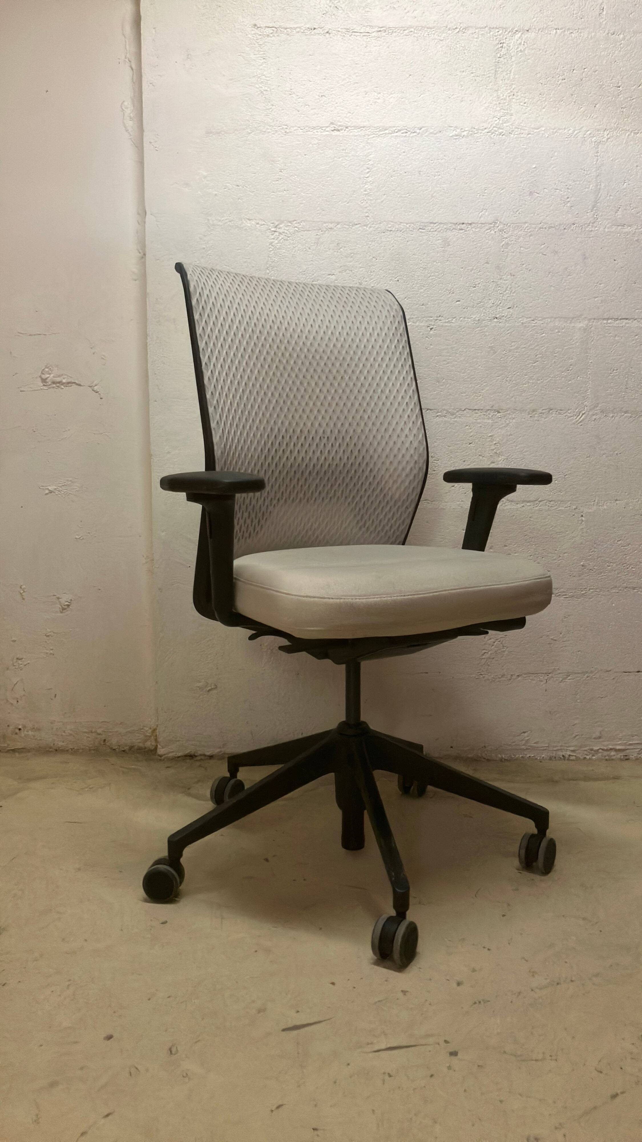 Office chair with wheels and mesh backrest.