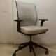 Office chair with wheels and mesh backrest.