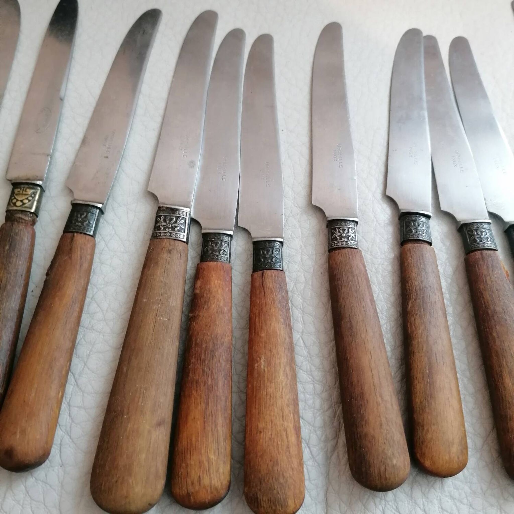 Old table knives and dessert knives, wooden handles, stainless steel blades