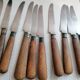 Old table knives and dessert knives, wooden handles, stainless steel blades
