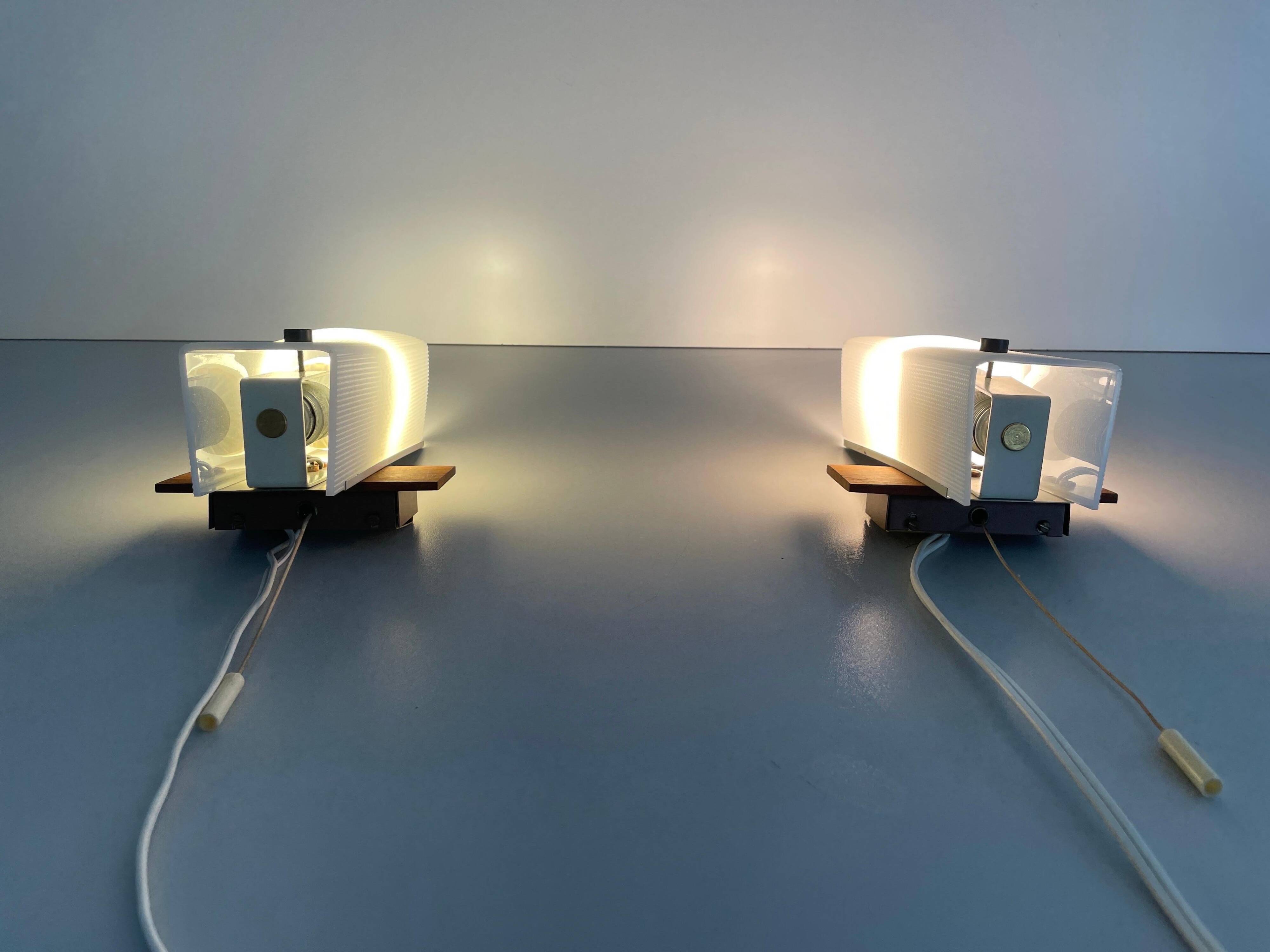 Mid-century wall lights in white plexiglass with a wooden base, 1960s, Germany.