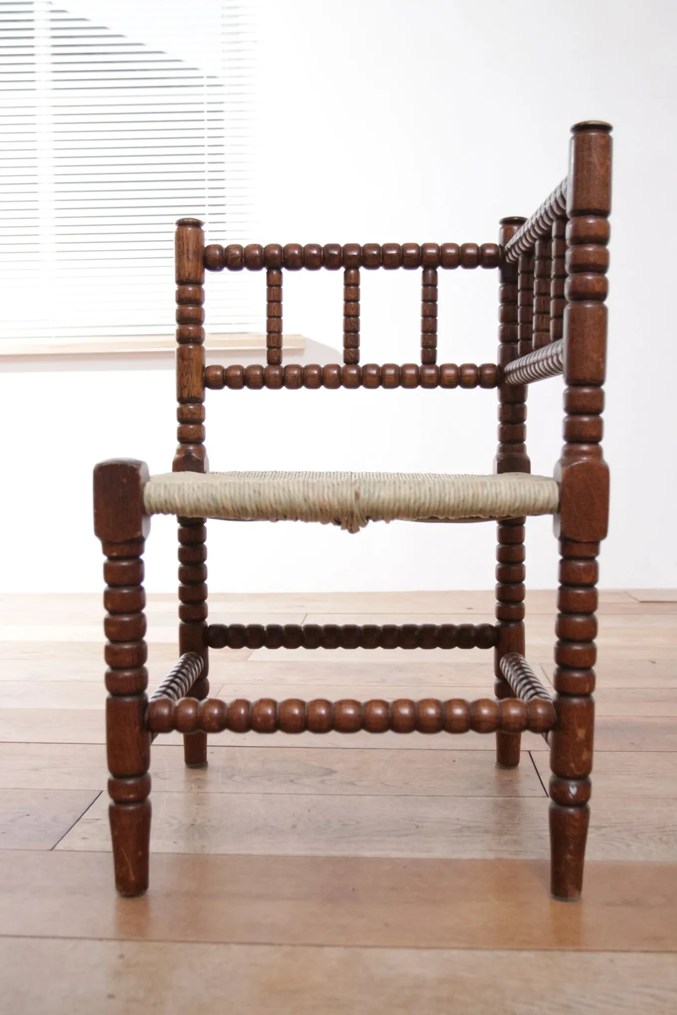 Antique Dutch oak corner chair with turned spindles and new rush seat