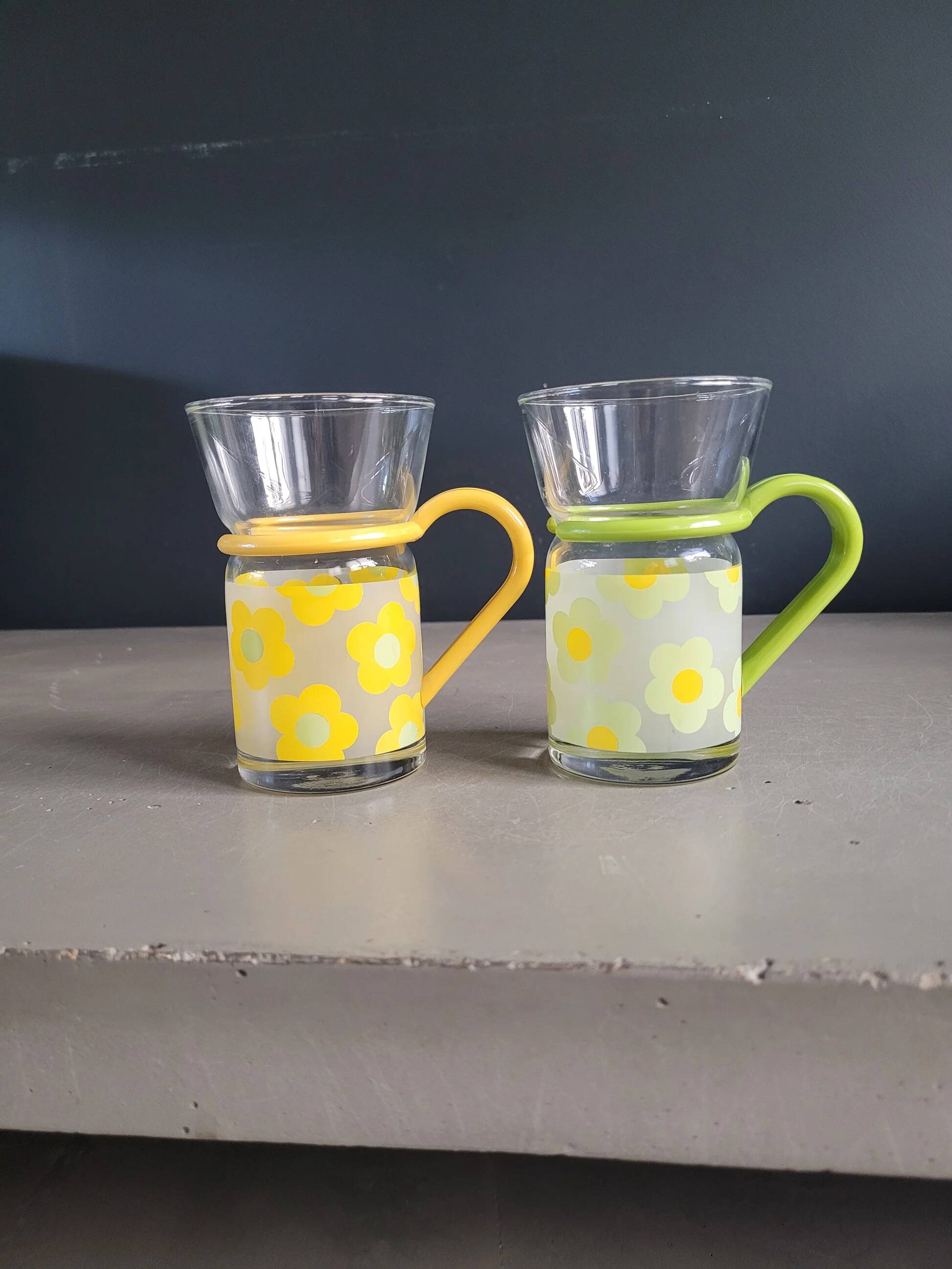 Pair of glass teacups with plastic handles