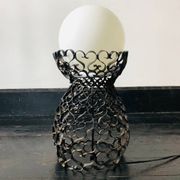 Black wrought iron lamp with a white glass globe.