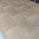 Oak dining table with a checkerboard top and extensions.