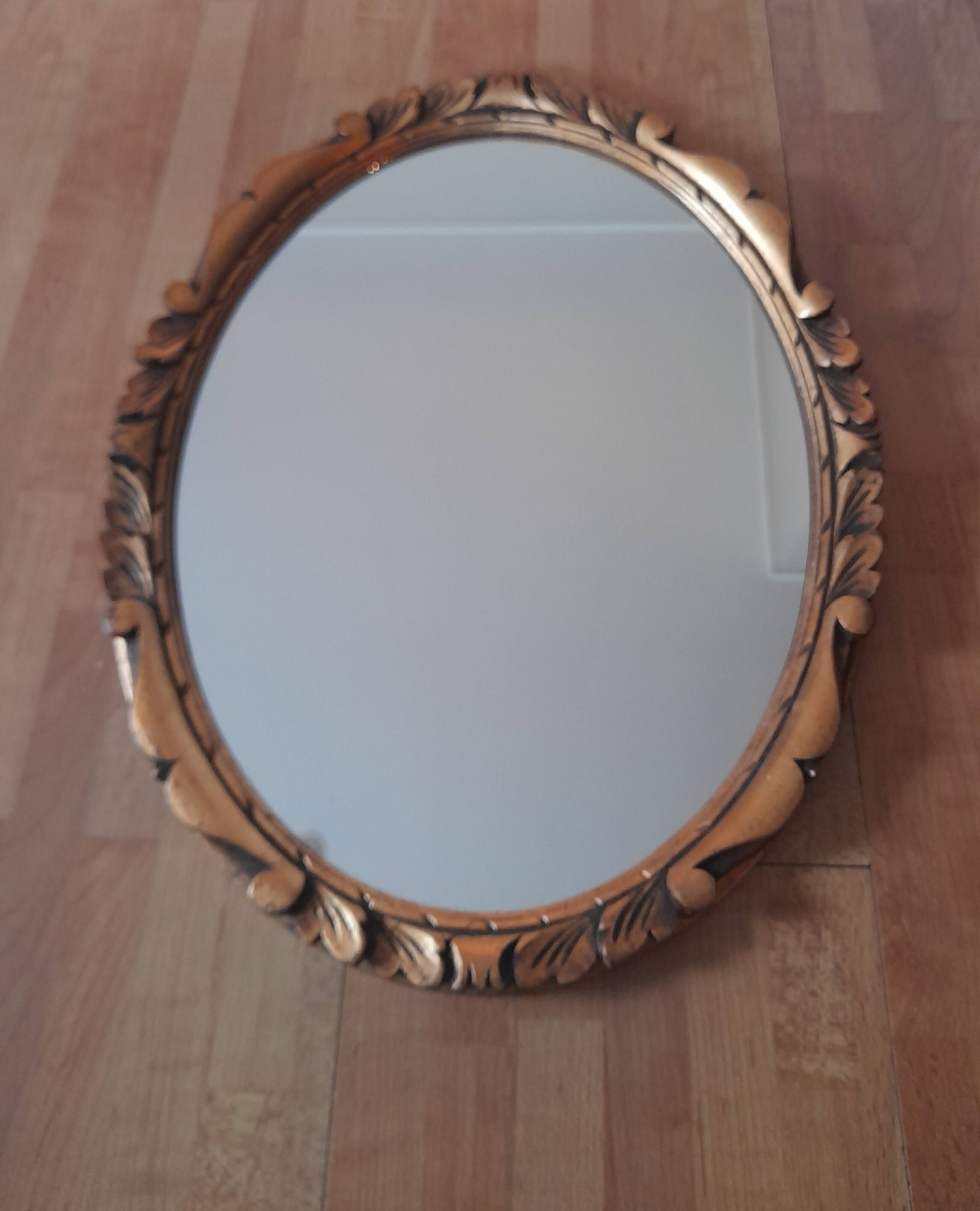 Oval wall mirror in gilded wood