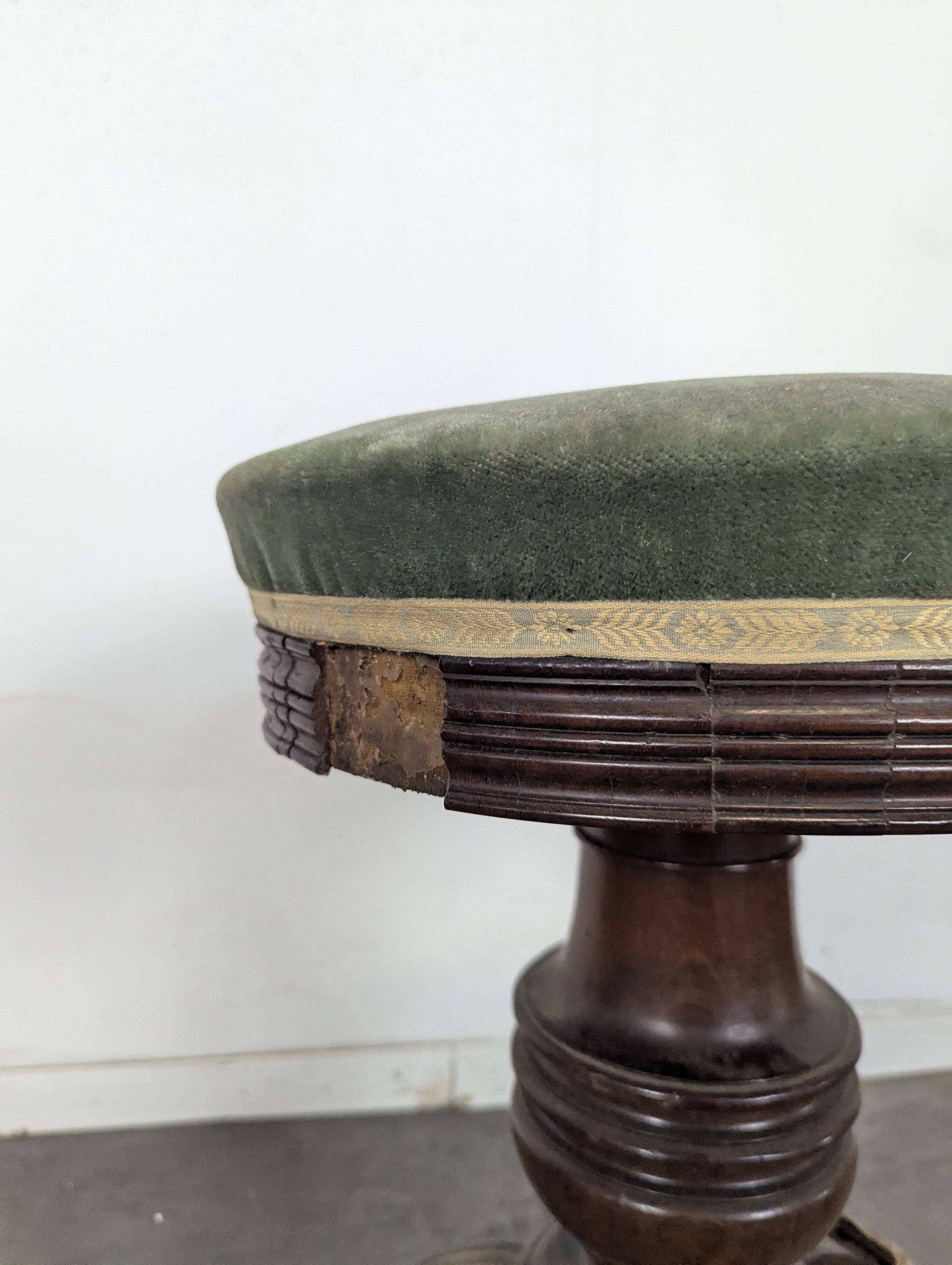 Green velvet piano stool with a turned leg.