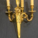 Pair of gilt bronze wall sconces with three lights in the Louis XVI style.