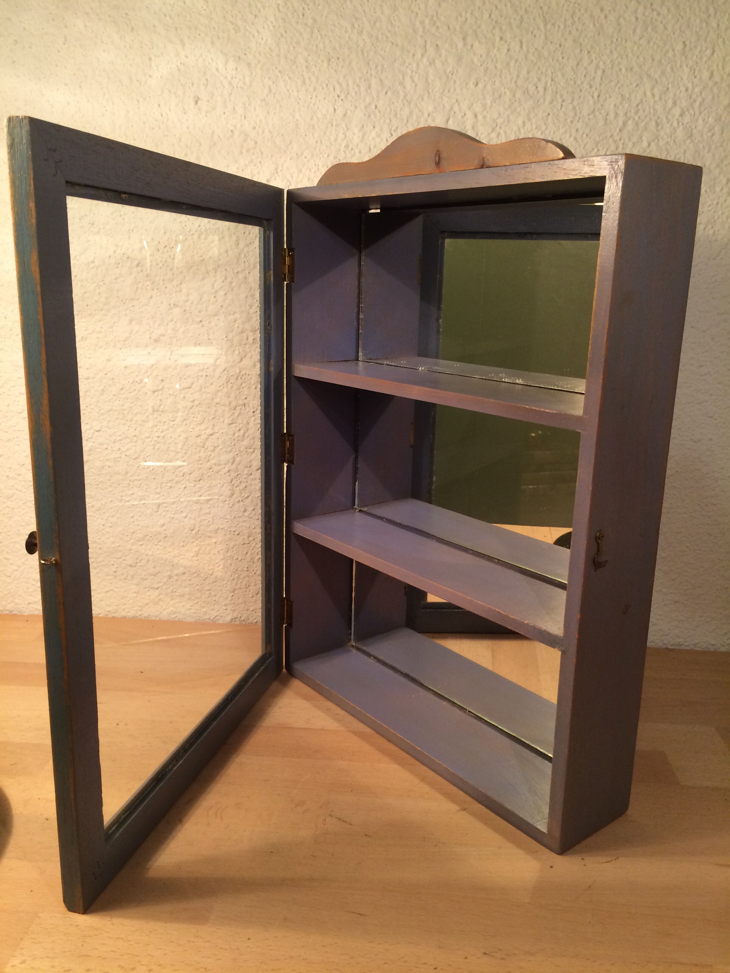 Display shelf with miniature blue wood and mirrors