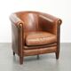 Sheepskin club armchair with a cognac colour finished with decorative nails