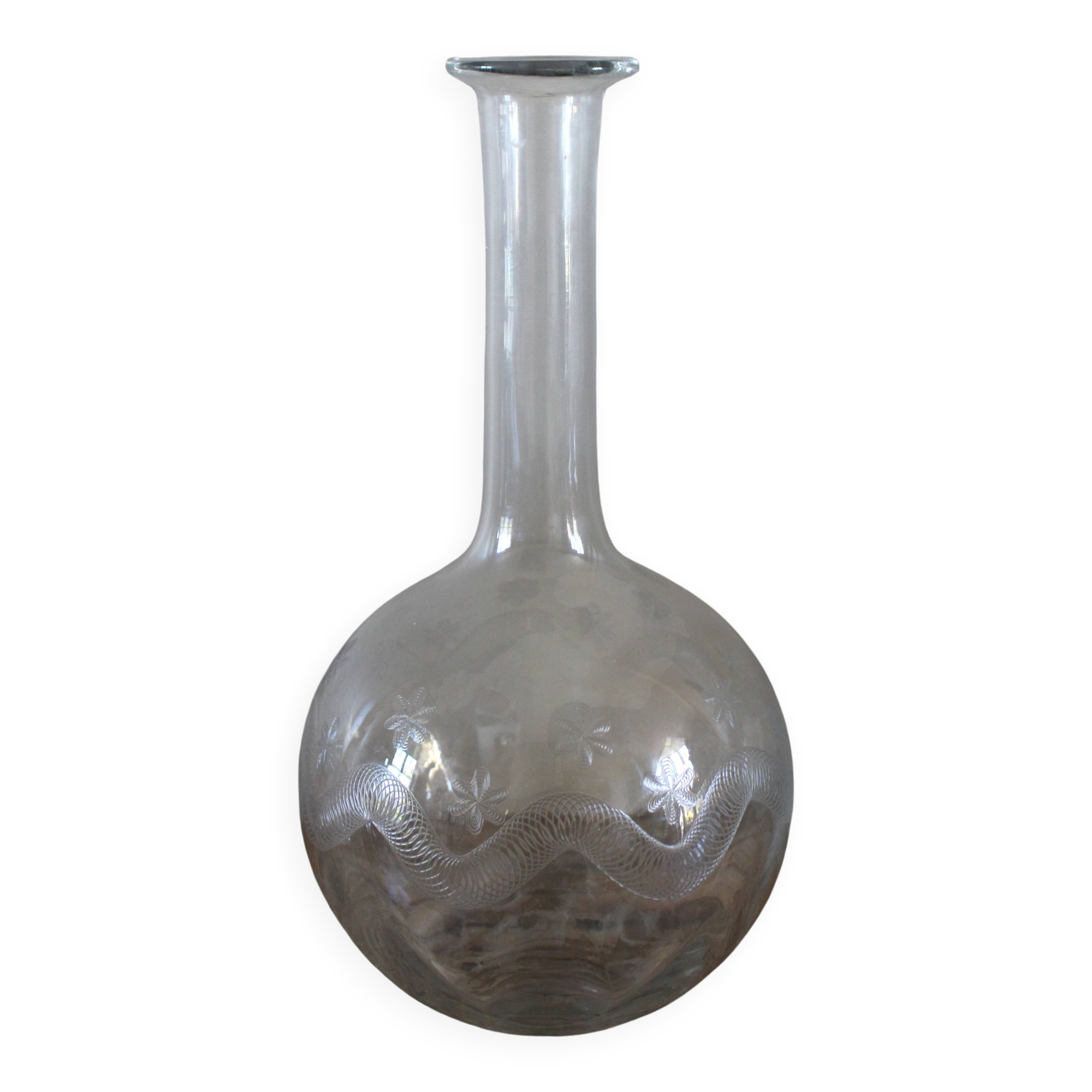 Antique glass carafe with a round belly and floral neck.