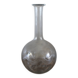 Antique glass carafe with a round belly and floral neck.