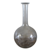 Antique glass carafe with a round belly and floral neck.