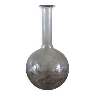 Antique glass carafe with a round belly and floral neck.