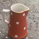 Milk jug, pitcher with white polka dots on orange earthenware, Sarreguemines and Digoin
