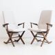 Pair of varnished wooden reclining armchairs, upholstered in lightweight fabric.