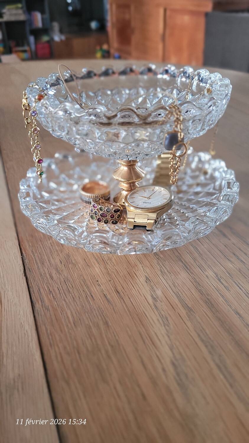 Two-tier display stand in cut glass mounted on a gold metal base.