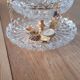 Two-tier display stand in cut glass mounted on a gold metal base.