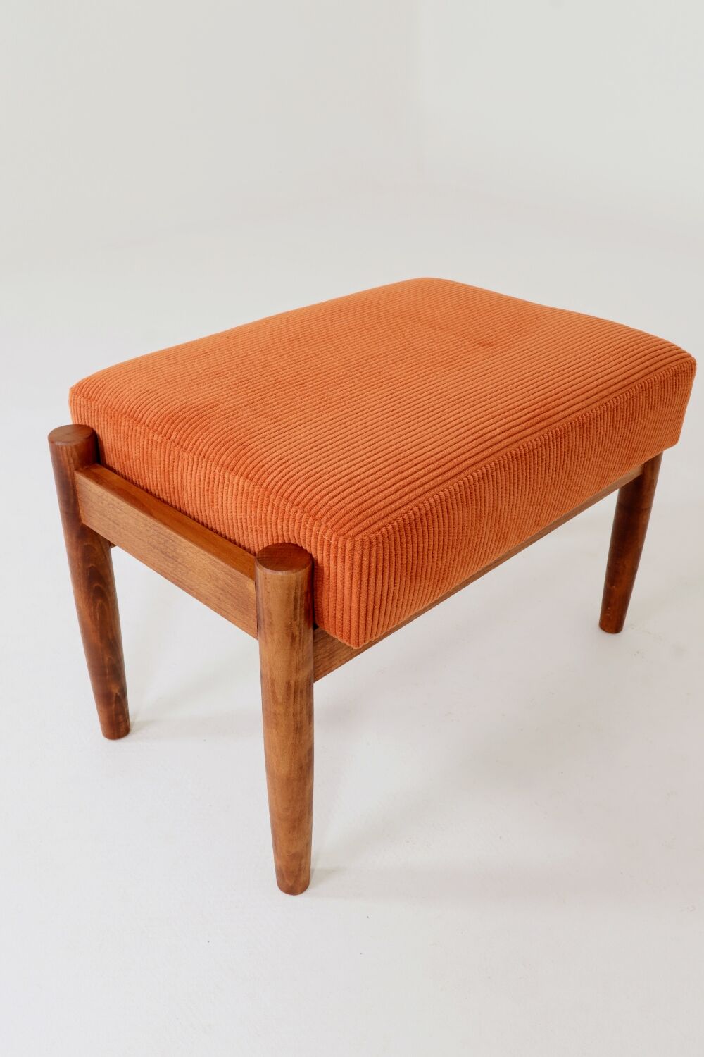 Vintage armchair and footrest in orange corduroy.