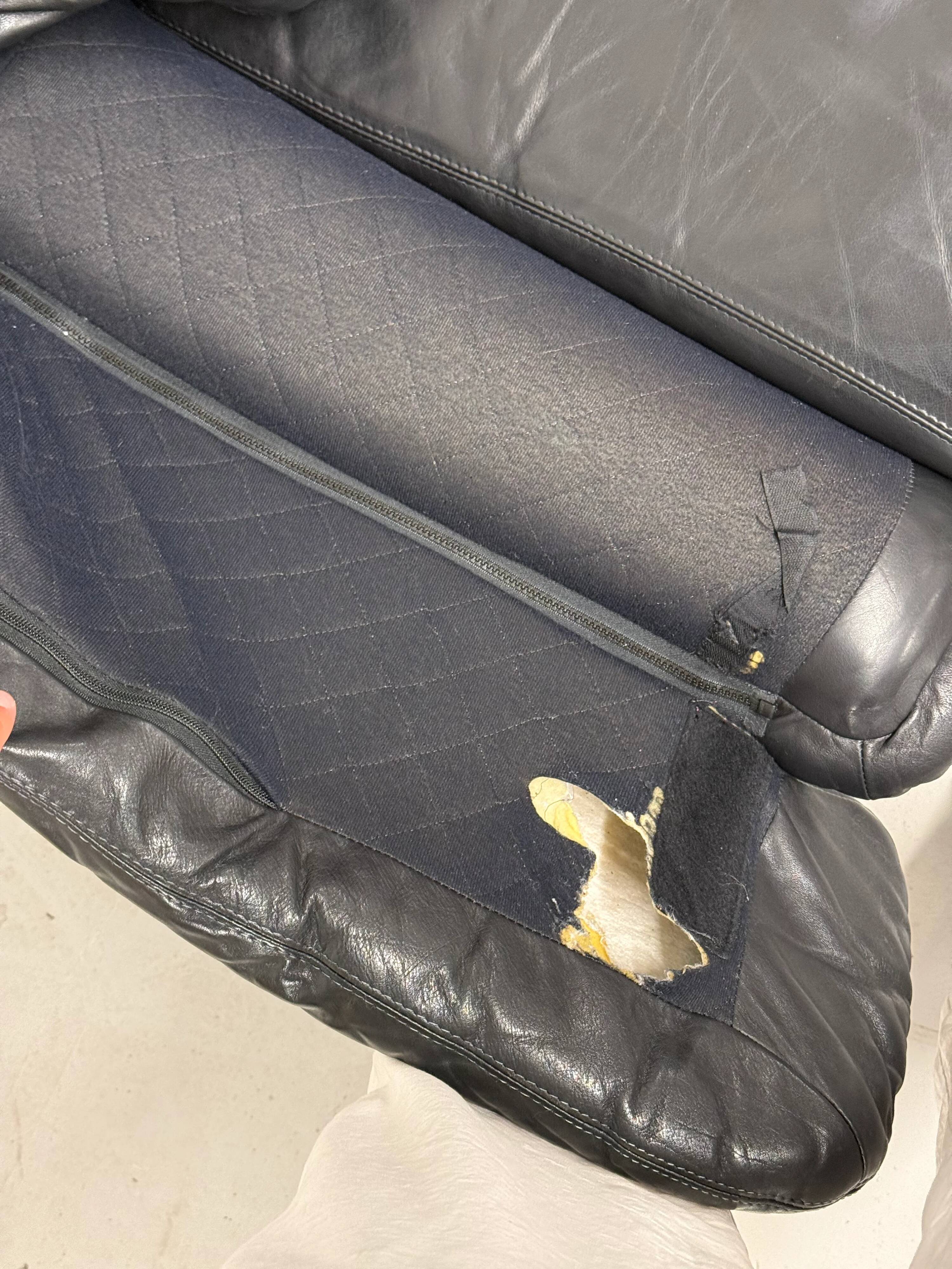 Vintage black leather lounge chair — low postmodern club chair from the space age.