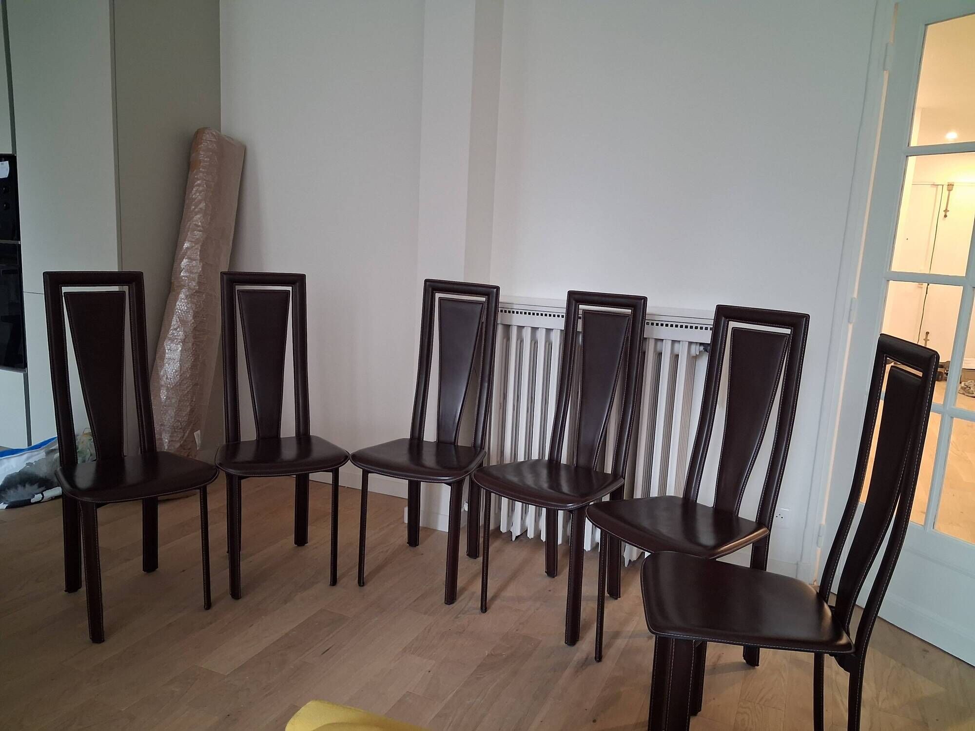 Set of 6 wooden chairs covered in leather.