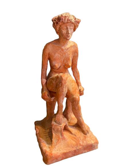 Painted plaster sculpture of a nude woman on a bench