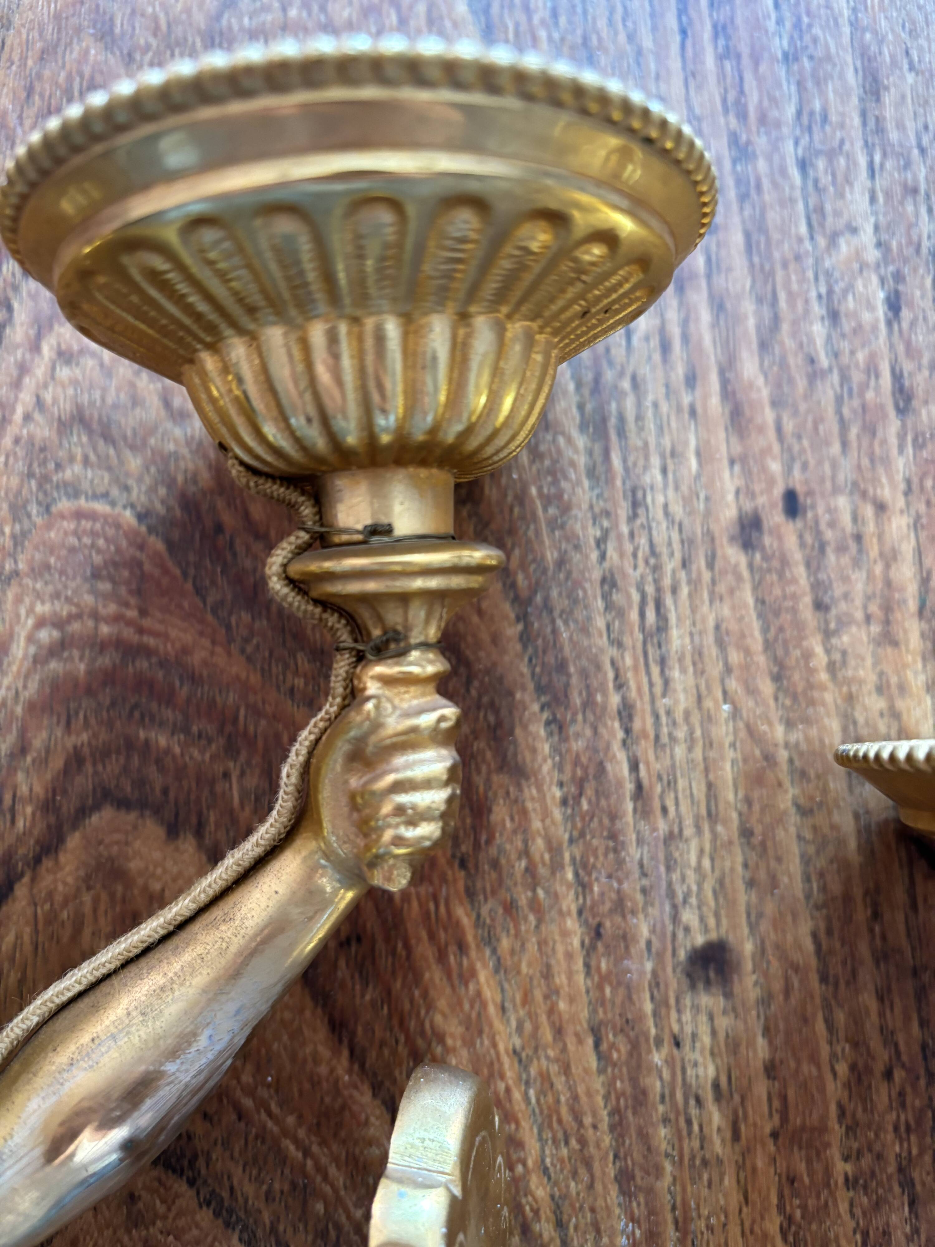 Pair of bronze wall sconces with outstretched arms and hands