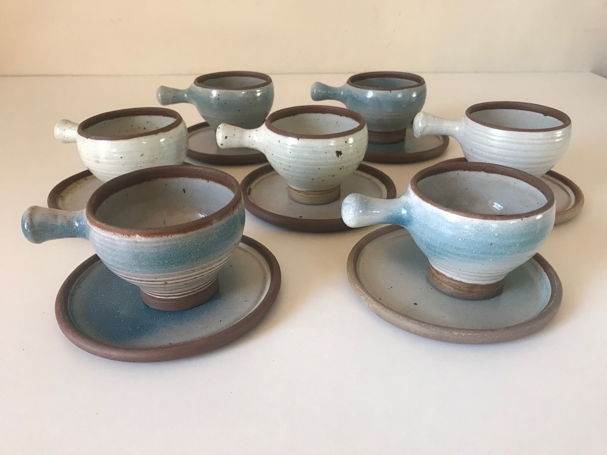 Lot 7 cups and saucers sandstone by Roger Jacques