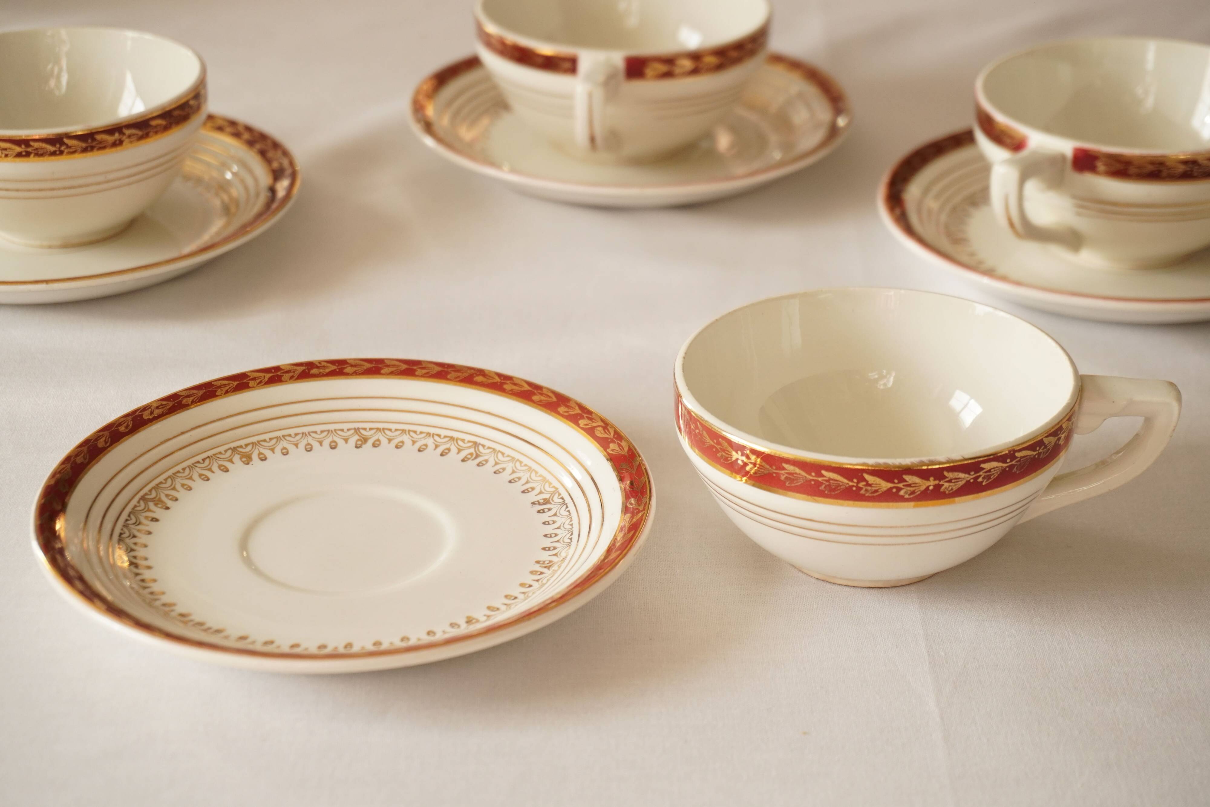 Set of 4 white, red and gold porcelain teacups, Ceranord