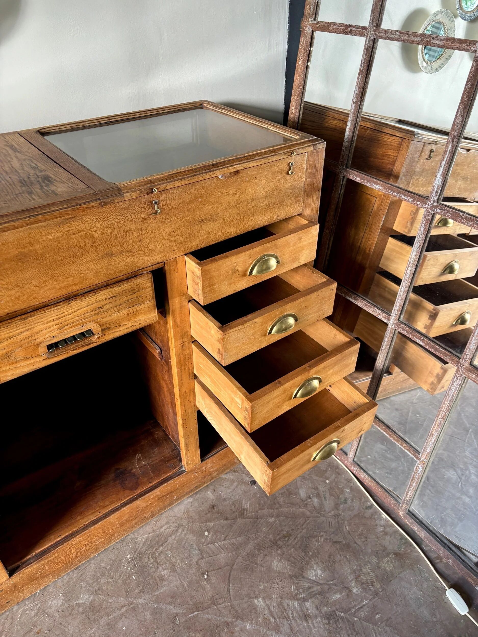 Counter, glass-fronted wooden workbench in dark wood, 8 drawers.