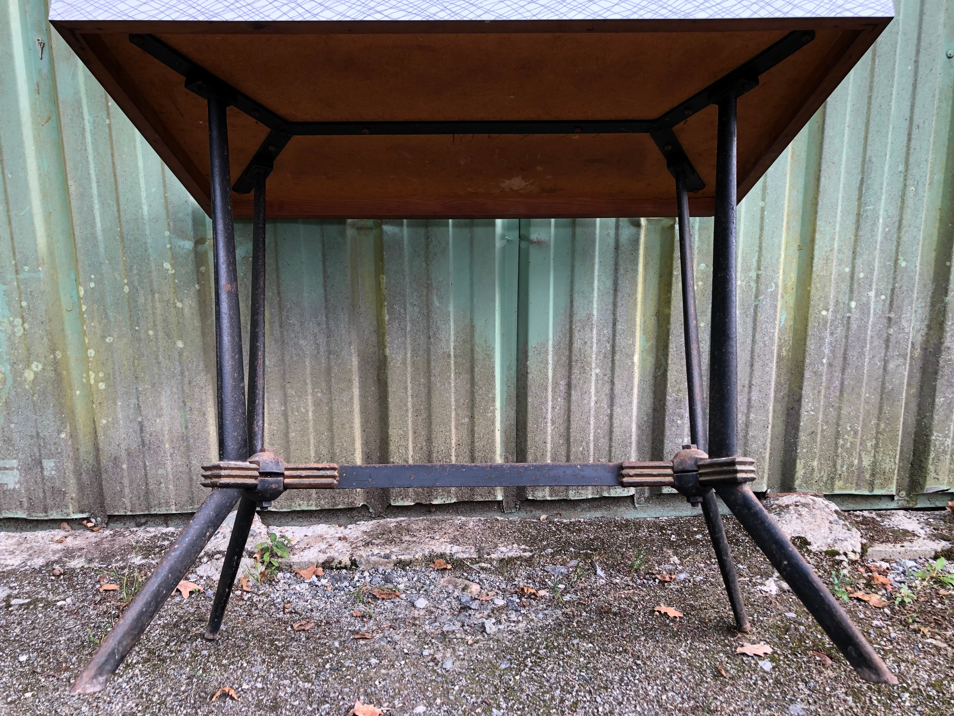 Vintage bistro table with an Art Deco style cast iron base and Formica top.