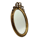 Antique oval gilded mirror with wooden frame and stucco detail